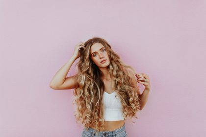 woman standing next to pink wall while scratching her head