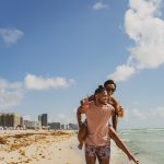 man and woman standing on beach during daytime