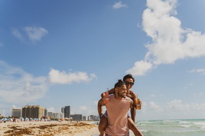 man and woman standing on beach during daytime