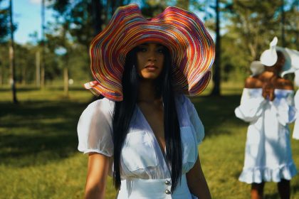 a woman wearing a colorful hat standing next to another woman