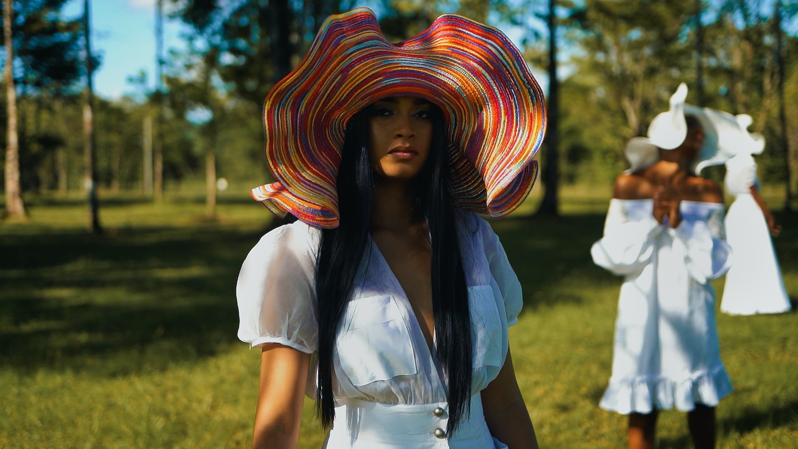 a woman wearing a colorful hat standing next to another woman